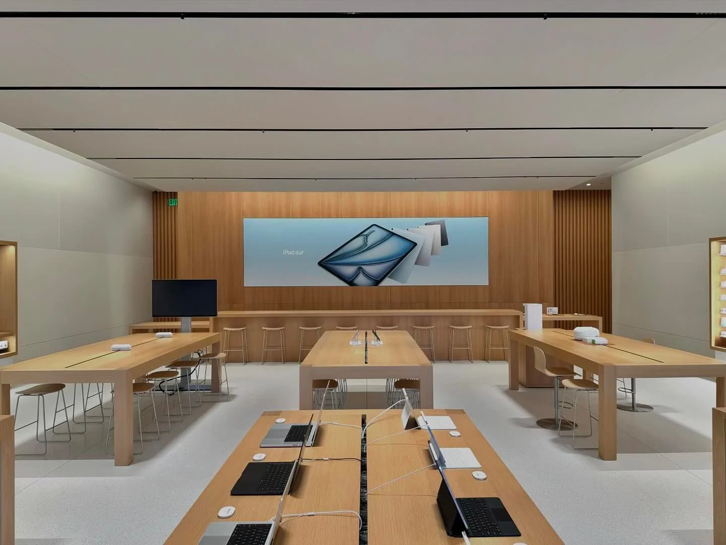 Apple retail interior with iPad Air signage and wooden product display tables